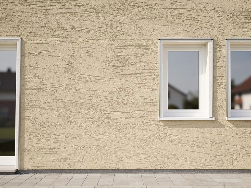 Façade de maison ravalée avec enduit gratté beige et encadrements soignés